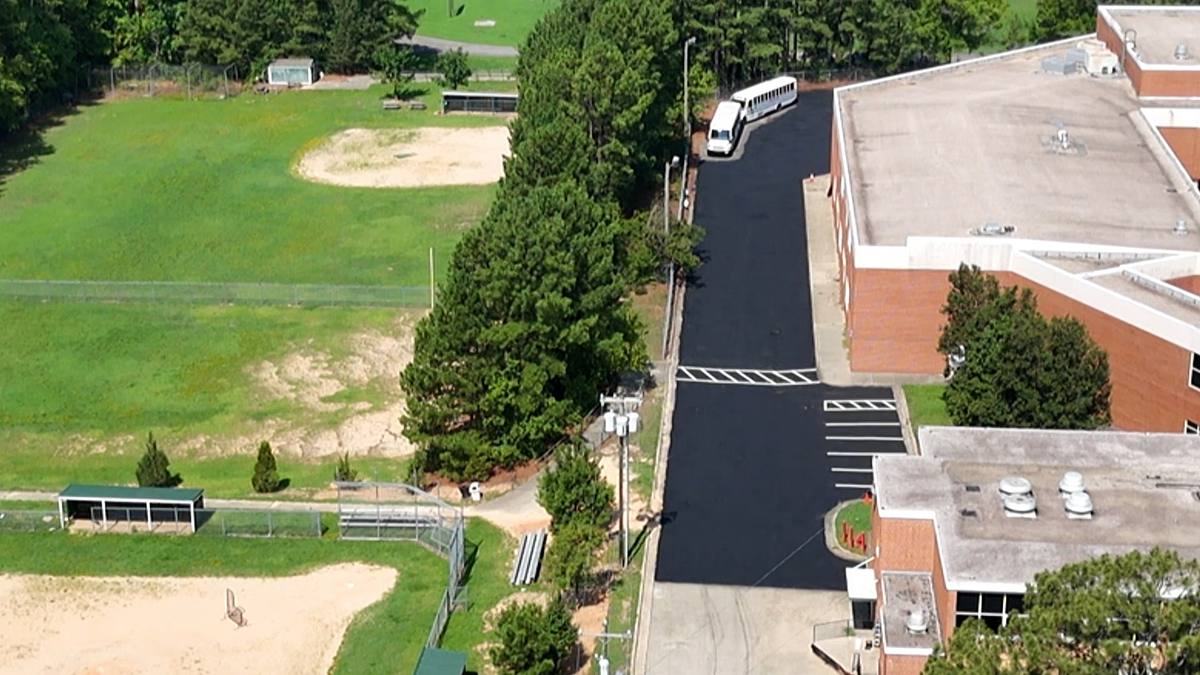 Freshly repaved campus drive and parking with new striping, aerial view